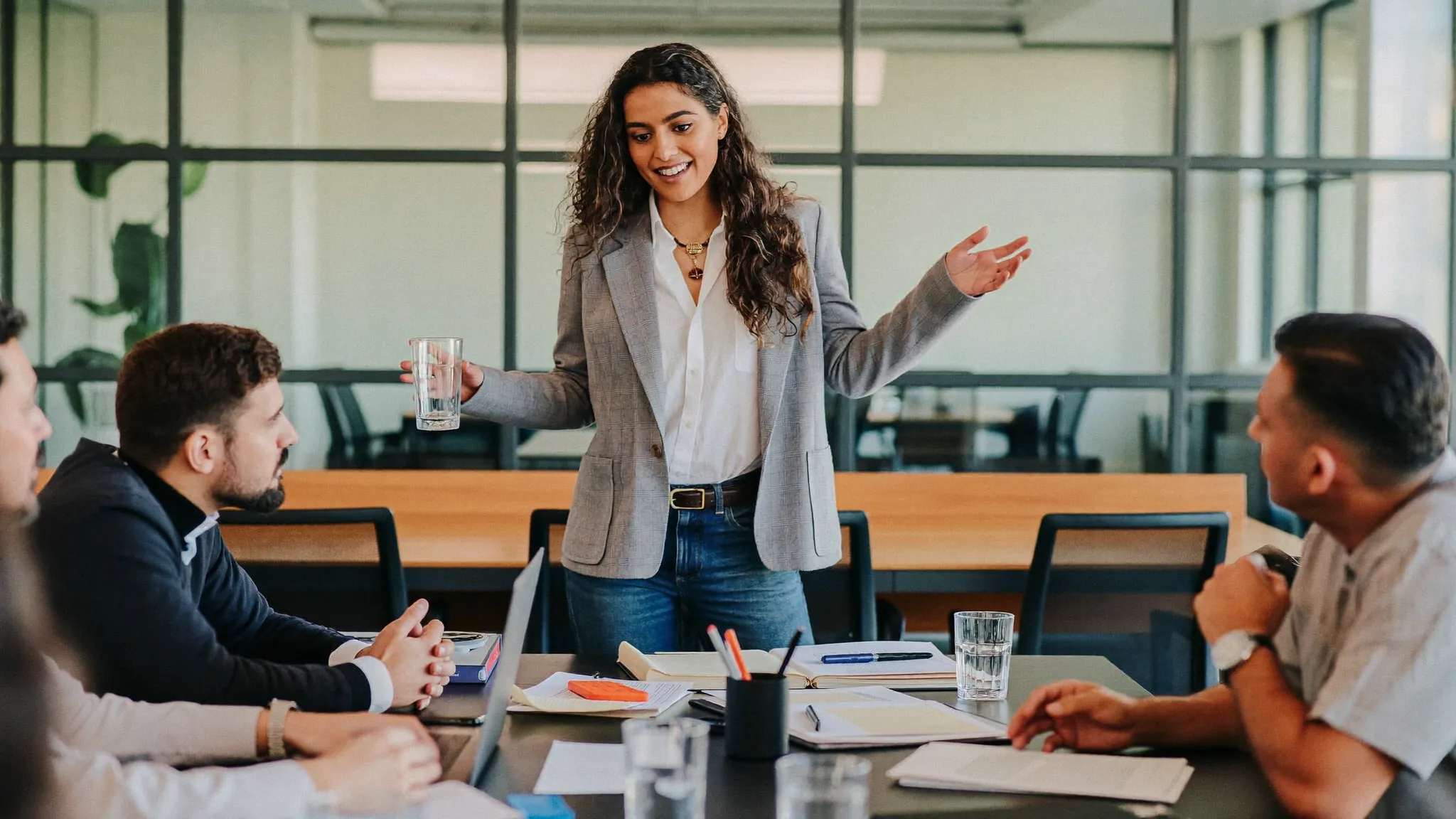 An experienced Indian professional giving a self-introduction in an office meeting — HireFresher