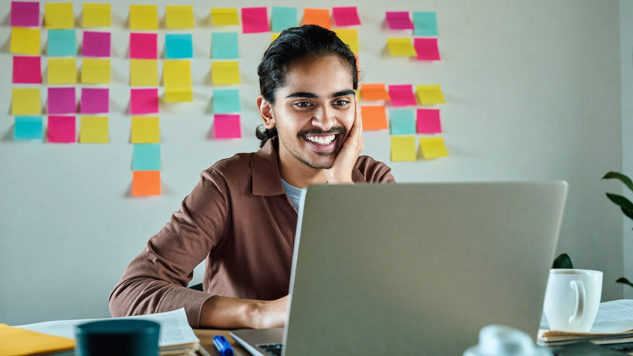 A young Indian professional organizing resume skills at a bright desk with sticky notes — HireFresher
