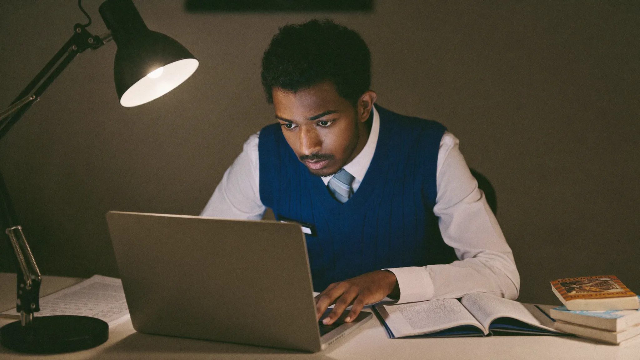 A focused Indian engineering student preparing for the TCS NQT exam at a study desk — HireFresher